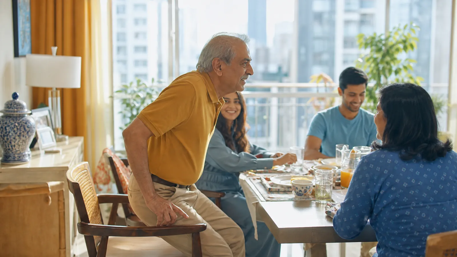 Older man rising from a sturdy dining chair with arms at family breakfast