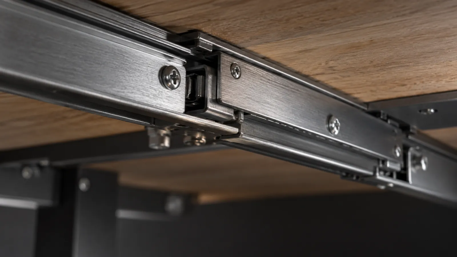 Illustrative close-up of dining-table extension rails beneath a timber top
