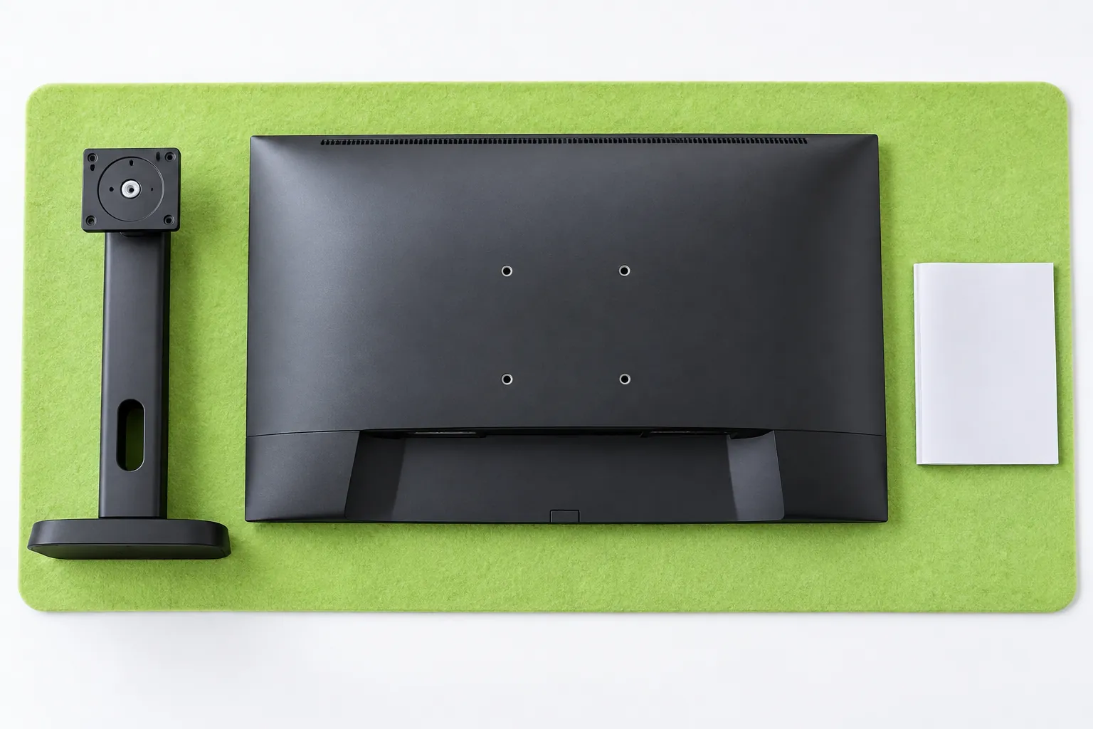 Illustrative rear monitor mounting holes and detached original stand on a protective mat