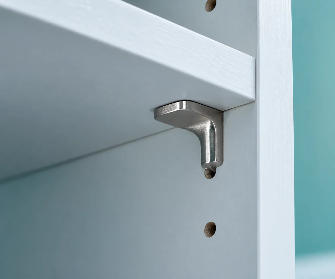 Close-up of a metal support beneath a pale shelf